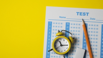 test de IQ sobre fondo amarillo, con reloj despertador, lápiz y goma
